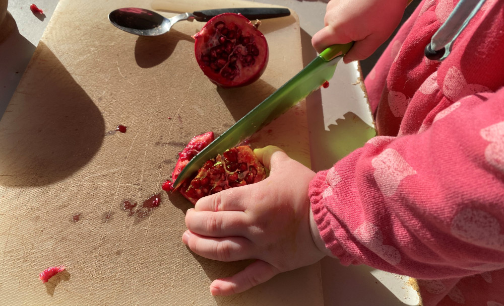 Child cutting pomegranate